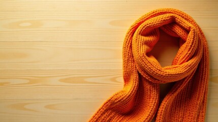 A Warm Knitted Orange Scarf on a Light Wooden Surface