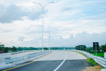 Long winding asphalt road on hills. Beautiful curved road in the middle of the forest. Side view of the road.