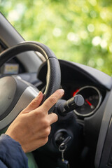 Lady hand holding steering wheel of car while driving.