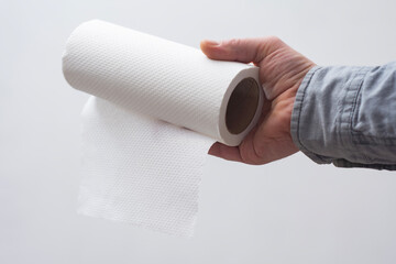 Clean white paper towel roll held by hand, for household use.