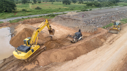 Yellow Excavator Performing Earthworks at Construction Site