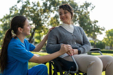 caregiver assists woman in wheelchair outdoors, showcasing compassion and support. scene reflects...