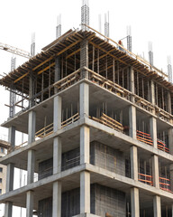 Concrete building under construction with scaffolding, steel reinforcements, and wooden planks