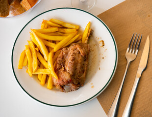 Plate with juicy delicious pork knuckle and French fries