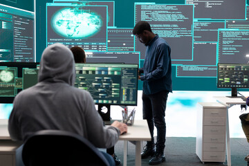 Fototapeta premium Governmental hackers analyzing data for cyber threat detection, looking at a big screen in high tech office. Highlight cyber intelligence, online security and prevention of digital threats.