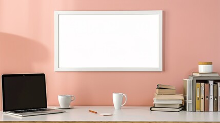 Obraz premium A white rectangular frame above a desk in a home office, surrounded by a cup, a laptop, and a pile of books. HD 8K mockup wallpaper Photographic Image