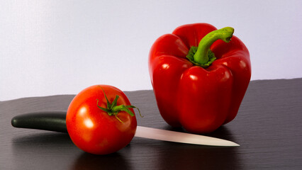 Roter Paprika mit Tomate und Messer