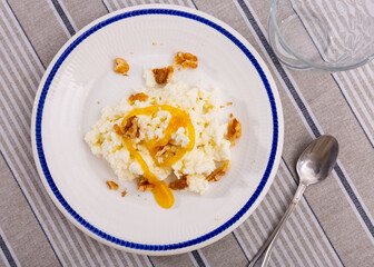 Portion of traditional Catalan dessert, mato with honey and, served on table with walnuts.