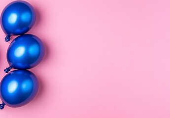Fototapeta premium Three Metallic Blue Balloons on a Pastel Pink Background for Celebratory Occasions
