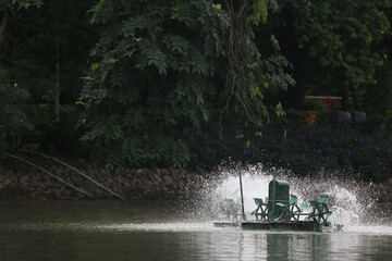 Water Aeration System: Capturing the mesmerizing dance of an aerator as it churns the water, surrounded by lush trees. A visual representation of water treatment and environmental conservation.