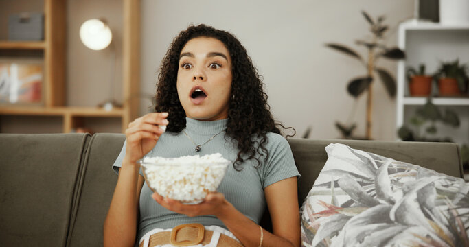 Shock, popcorn and movie with woman on sofa for streaming service, home cinema or film. Watching tv, subscription and thriller series with person in living room of apartment for plot twist and snack