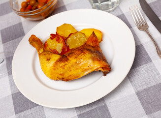 Spicy bbq chicken legs with with boiled potato close-up on a plate