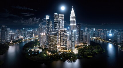 Obraz premium Aerial view of illuminated skyscrapers at night on an island city, suitable for city lifestyle or travel promotion