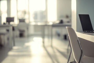 Modern office interior, laptop on table, bright sunlight, workspace