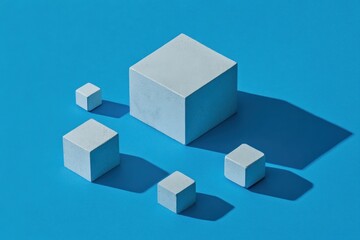 Fototapeta premium White cubes of varying sizes cast shadows on a blue background.