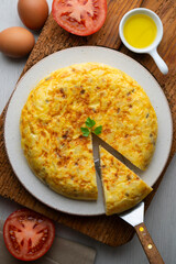 Overhead view of a traditional Spanish potato omelette on a wooden base.