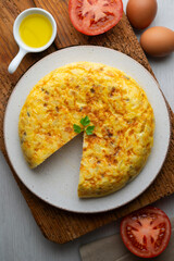 Overhead view of a traditional Spanish potato omelette on a wooden base.