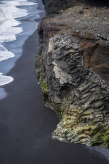 An interesting shaped rock at the coast of iceland on black sand beach near vik i myrdal