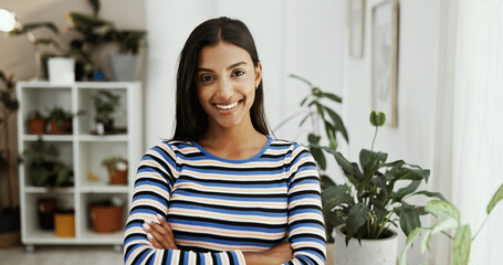 Sustainable business, confident and woman with arms crossed, smile and environmental consultant in office. Portrait, eco friendly and Indian person with social responsibility, plants and project