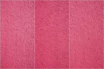 Fototapeta premium Pink wall with three different shades of pink. The wall is made of a textured material