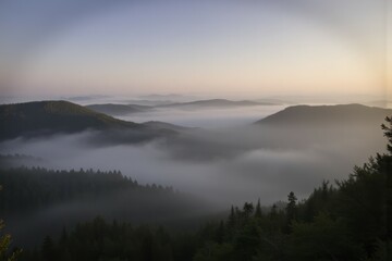 Fototapeta premium Misty Mountain Range Depicts Tranquility in a Serene Early Morning