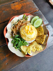 Nasi pecel and sego pecel are typical Javanese Indonesian rice dishes served with pecel sauce,...