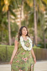 Fototapeta premium A woman in a floral dress and lei enjoys a peaceful stroll in paradise