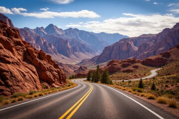 Fototapeta premium A winding road leading through mountains with blue skies above