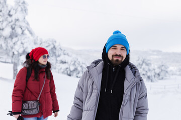 Young adult man & middle age woman hiking on snow covered highland