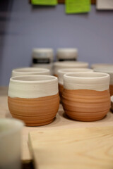 Handmade ceramic cups with a raw terracotta base and white glaze