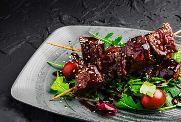 Savory skewers with grilled meat and fresh greens on a plate