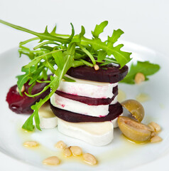 Gourmet beet and goat cheese salad on white plate