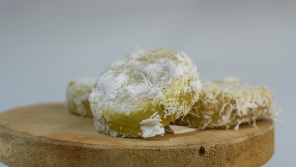 Lupis is a traditional Indonesian food, with the main ingredients being white sticky rice, grated coconut and melted palm sugar. served on a  plate