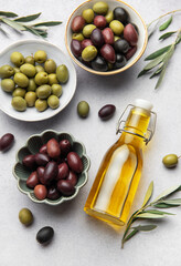 Assorted olives with olive oil and olive branches creating culinary delight