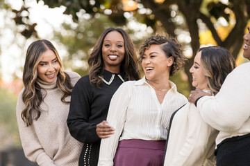 A joyful group of friends sharing laughter in an autumn park setting