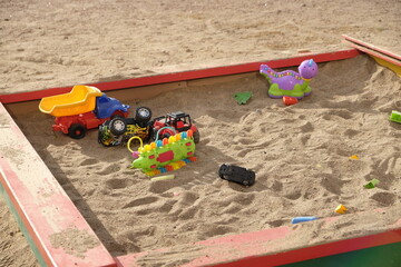 Children's toys are in the sandbox on the playground