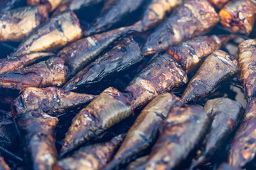 Seafood, fresh hot smoked salmon on traditional African oven grill for sales and preservation.