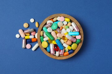 Various pills in a bowl on a blue background