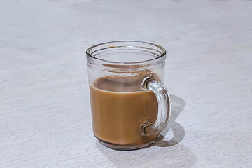 Coffee is in a glass on the dining table ready to drink