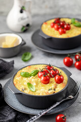 classic Greek pasta dish with a vegetable filling under a cheese crust on a gray background.