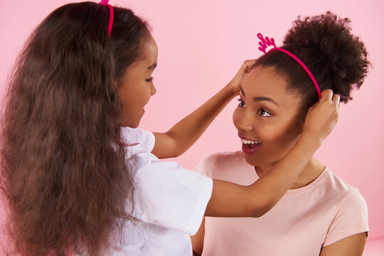 African Am erican daughter puts crown on head