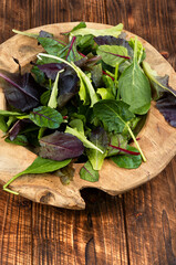 Fresh salad in a rustic wooden bowl.