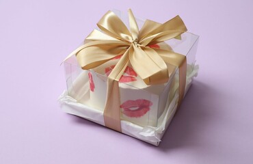 Colorful packaged cake decorated with red lips on a colored background