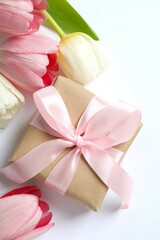 Beautiful fresh tulips with gift box on white background