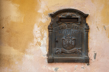 Cassetta della posta antica su muro scrostato.