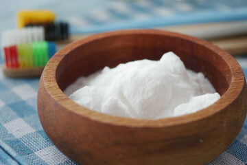 Baking soda bowl with colorful toothbrushes on a tablecloth