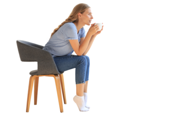 Young woman sitting in armchair and drinking coffee on a transparent background