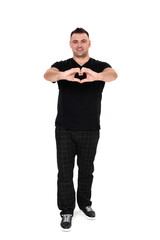 A handsome dark-haired man in a black T-shirt, trousers and sneakers on a white background