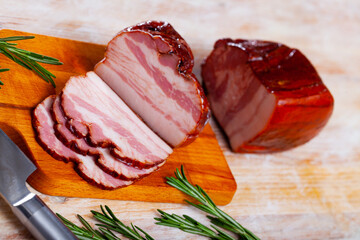 Piece of tasty smoked pork belly on wooden surface closeup