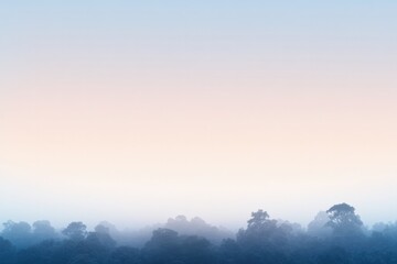 Obraz premium Calm mist envelops distant trees, blending soft colors of dawn i